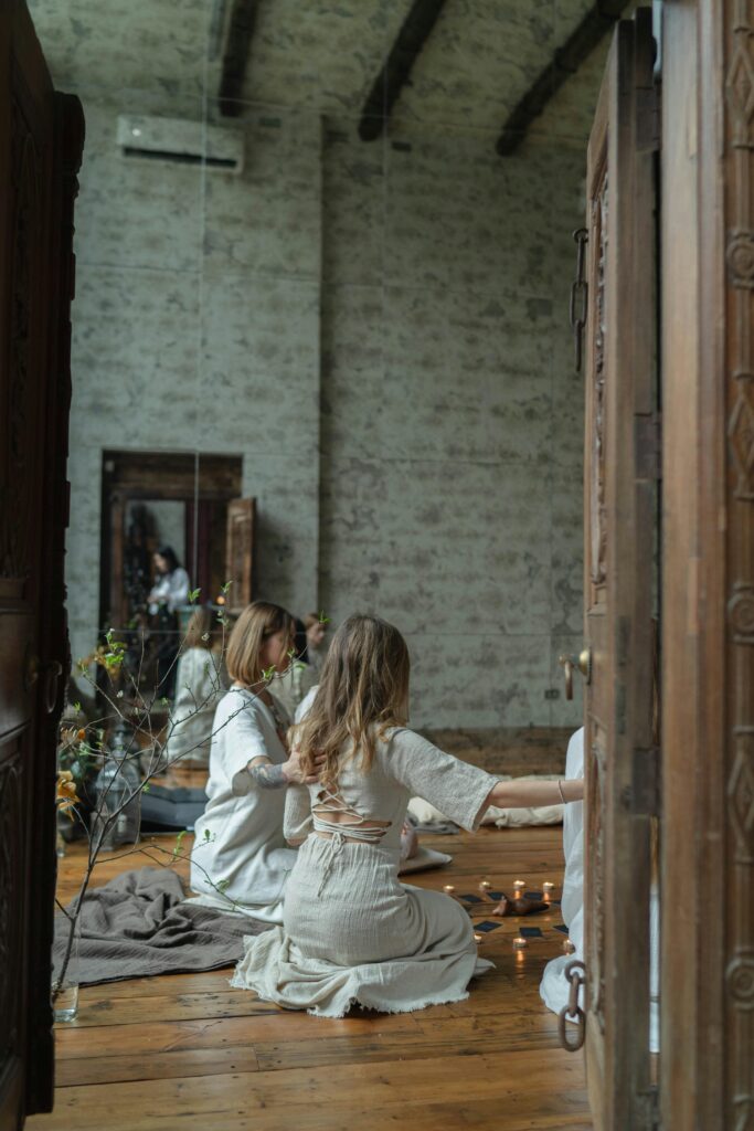 2 Women Sitting on Brown Wooden Chair